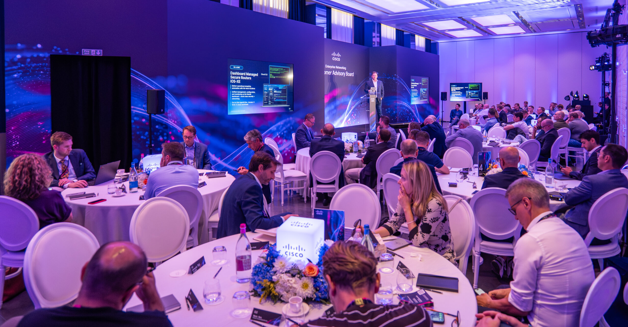 Corporate conference with speakers and seated attendees
